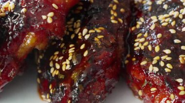 Ağzını sulandıran Kore barbekü soslu tavuk butları gochujang kaplı, haşhaş tohumlarıyla süslenmiş..
