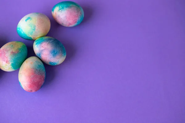紫色の背景にショッピングカート 木製のウサギと春の花でカラフルな卵とイースター組成 紫色で描かれた卵のイースターフレーム スペースのコピー — ストック写真