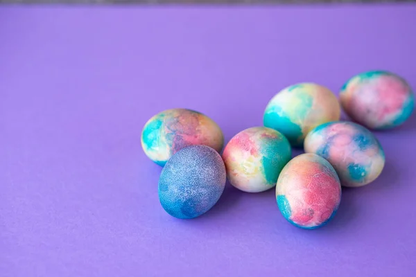 Paascompositie Met Kleurrijke Eieren Winkelwagen Houten Konijntje Lentebloemen Paarse Achtergrond — Stockfoto