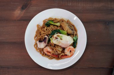 Mee Pad Hokkien veya Karışık Kızarmış Hokkien Mee veya Hokkien Eriştesi. Phuket Orijinal Hokkien Eriştesi deniz ürünleri, domuz eti ve sebzelerle kızartılmış kalın sarı erişteden oluşur. Seçici odak