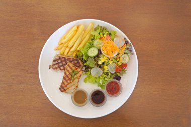 Biftek, patates kızartması ve salatayla servis ediliyor. Üst görünüm, seçici odak