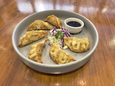 Gyoza, seçici odaklanma. Gyoza tavada kızartılmış Japon köfteleridir. Altında gevrek ve altın renginde ve içinde de sulu..