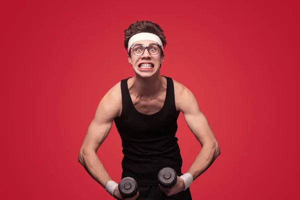 Aktif Giysili Gözlüklü Sıska Bir Genç Adam Halterlerle Egzersiz Yapıyor — Stok fotoğraf