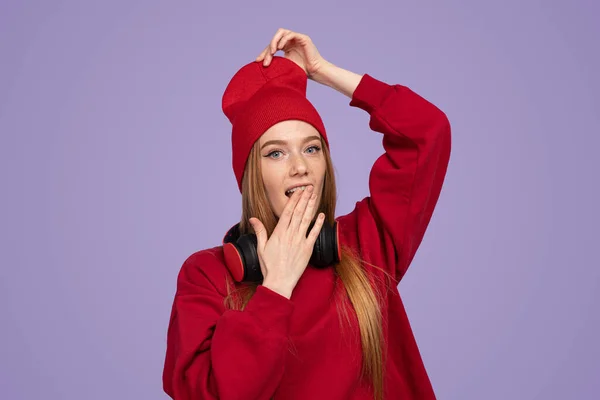 Astonished Young Woman Red Sweatshirt Headphones Touching Hat Covering Mouth — Stock Photo, Image