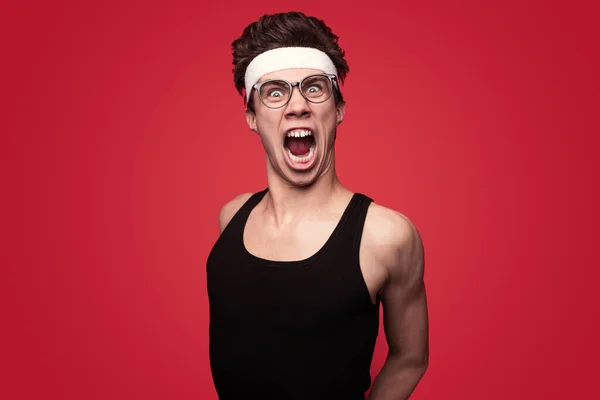 Kırmızı Arka Planda Spor Yaparken Saçı Bantlı Gözlüklü Agresif Genç — Stok fotoğraf