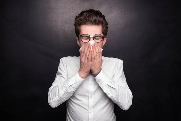Chory Młodzieniec Białej Koszuli Okularach Przykrywający Twarz Chusteczką Dmuchający Nos — Zdjęcie stockowe