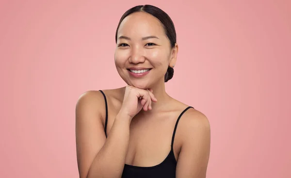 スタジオでピンクの背景に隔離されたカメラを見て歯の笑顔と肯定的な若いアジアの民族の女性の美しさの肖像画 — ストック写真