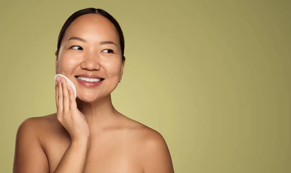 Cheerful Young Asian Female Touching Clean Skin Reusable Makeup Disk — ストック写真