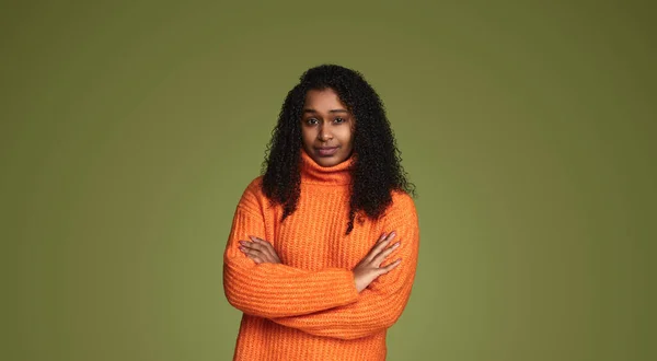 年轻的非洲裔美国女性 卷发橙色毛衣 手牵手站在绿色背景下看着相机 — 图库照片