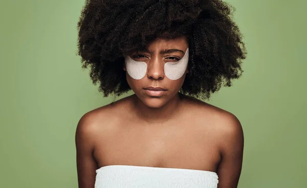 Молодая Уставшая Афроамериканка Афроволосами Повязками Глазах Смотрит Камеру Зеленом Фоне — стоковое фото