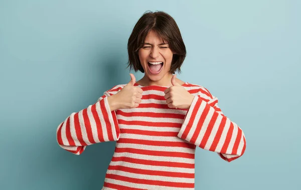 Çizgili Tişörtlü Mutlu Spanyol Kadın Mavi Arka Planda Dikilirken Gülümsüyor — Stok fotoğraf