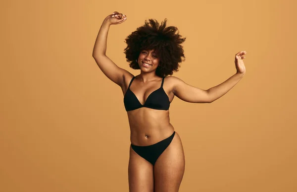 Leende Afrikansk Kvinna Svarta Underkläder Höja Armarna Samtidigt Hoppa Och — Stockfoto