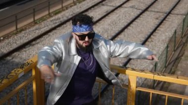 Genç otantik adam sokaklarda dans ediyor. Sokak giysisi ve güneş gözlüğü takan Hip-Hop break dans hareketleri yapıyor..