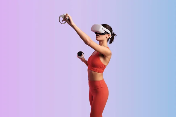 stock image Side view of astonished unrecognizable female in VR goggles using gamepad controllers while playing video game against violet and blue background
