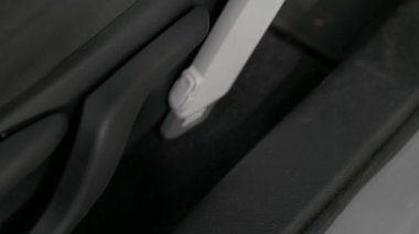 Closeup footage of cleaning car seat with vacuum cleaner. Car interior washing service with cordless modern vacuuming equipment.