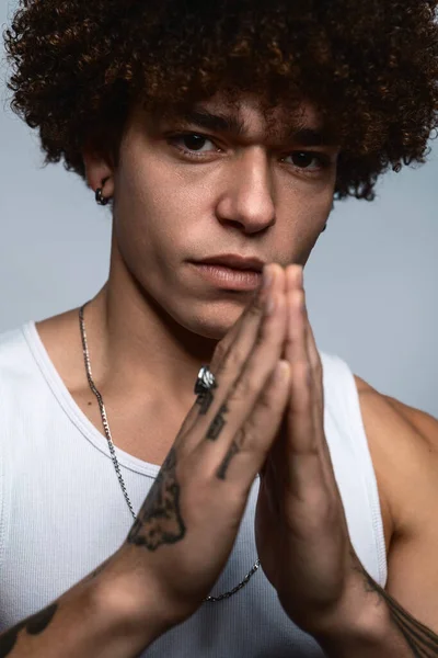 Handsome Ethnic Male Afro Hairstyle Tattooed Arms Doing Prayer Gesture — Stockfoto