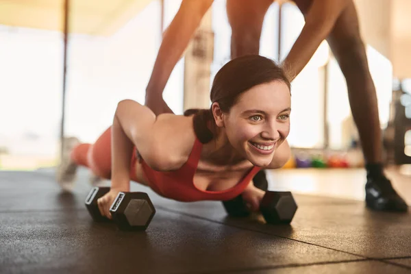 Glimlachende Jonge Sportvrouw Doet Plank Oefening Met Halters Terwijl Zwarte — Stockfoto