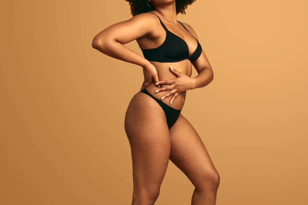 Siyah Çamaşırlı Bej Arka Planda Duran Vücudunu Gösteren Afrikalı Kadın — Stok fotoğraf