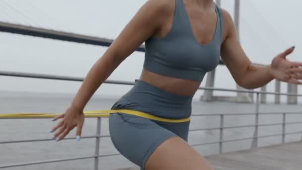 Panning Shot Revealing Athletic Woman Running Place Using Resistance Band — Stock Video