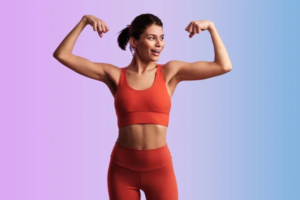 Young Muscular Smiling Female Athlete Red Sportswear Showing Biceps Fitness — Stock Photo, Image