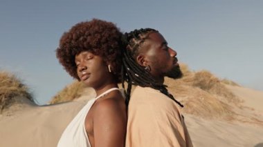 Güzel siyah bir kadın ve Afrikalı bir erkeğin sırt sırta verip derin bir bağı sembolize eden kavramsal bir sanatsal video.