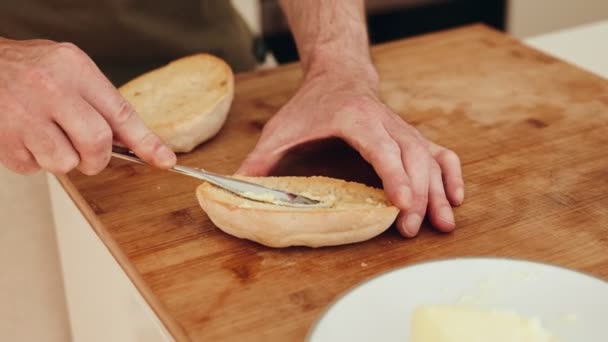 Zbliżenie Męskich Rąk Fachowo Rozprowadzających Masło Tostowej Połówce Bułki Desce — Wideo stockowe