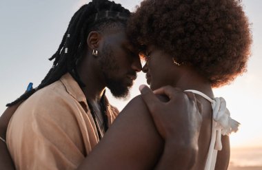 Düşük açılı Afrikalı bir adam, kırsal alanda aşk ve tutku kavramında Afro saçlı kız arkadaşına sarılıyor.