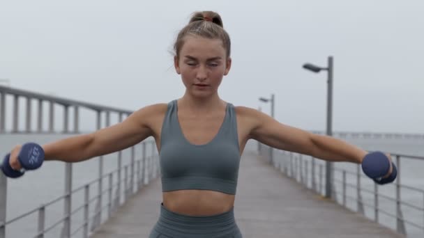 Een Vastberaden Jonge Vrouw Sportkleding Voert Halter Laterale Verhogingen Een — Stockvideo