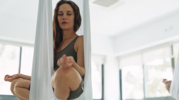 一个成年女人在一个飞瑜伽吊床上找到了宁静 在明亮的画室里沉思着荷花的姿势 — 图库视频影像