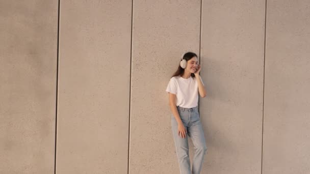 Ein Teenie Mädchen Legerer Kleidung Lehnt Einer Wand Hört Laute — Stockvideo