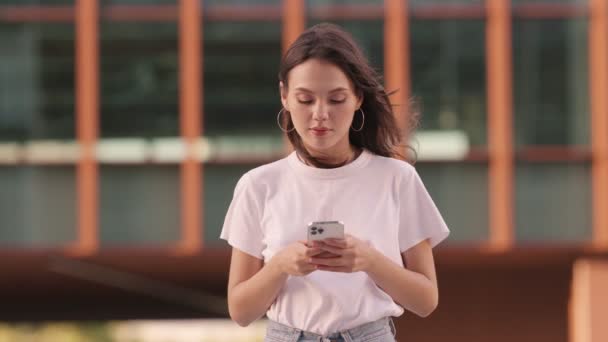 Una Mujer Joven Espera Alguien Mientras Usa Teléfono Inteligente Buscándolos — Vídeo de stock