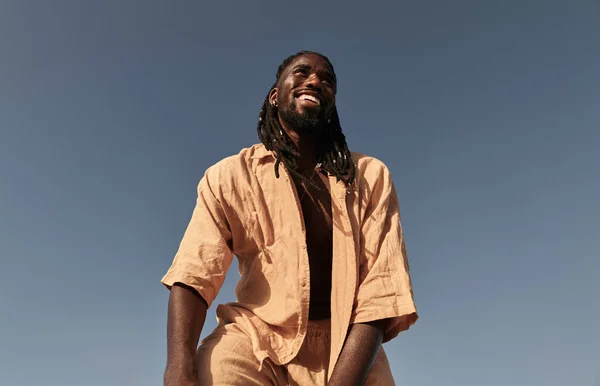 Χαμηλή Γωνία Του Χαρούμενου Μαύρου Άνδρα Μπεζ Ντύσιμο Στέκεται Ενάντια Φωτογραφία Αρχείου