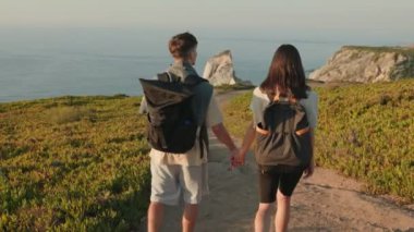 Genç bir çift birlikte seyahat eder, güzel bir manzarada yürüyüş yaparlar. Sırt çantalarıyla bir yürüyüş yolunda el ele yürürler. Arka plan