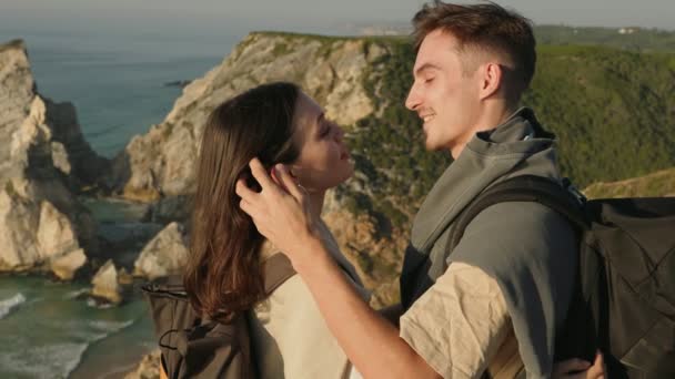 息をのむような自然の風景の中で ハイキングバックパック そして優しい瞬間を共有する若いカップルの側面 — ストック動画