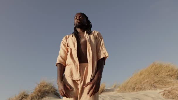 Γαλήνιος Μαύρος Άνδρας Φαρδιά Μπλούζα Στέκεται Έξω Έναν Αμμόλοφο Της — Αρχείο Βίντεο