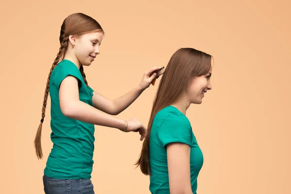 Cheerful Girl Helps Her Mother Hair Brushing Side View Beige Royalty Free Stock Photos