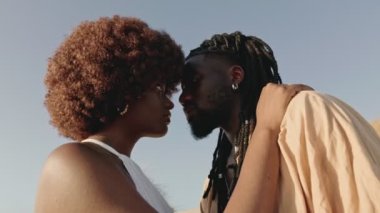 Genç Afrikalı bir çiftin yakınlaşması, derin bir aşk, göz temasıyla kucaklaşması, romantik bir bağ yaratıyor.
