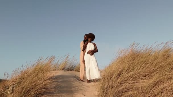 Casal Negro Amoroso Trajes Brancos Bege Abraçando Uma Duna Areia — Vídeo de Stock