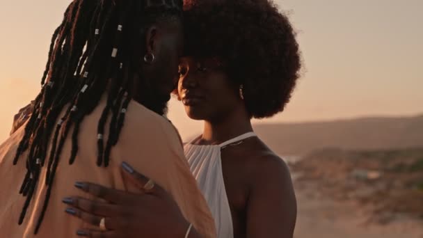 一个特写镜头捕捉了一对时髦的非洲黑人夫妇拥抱在一起的亲密时刻 他们相互凝视着美丽的日落背景 — 图库视频影像