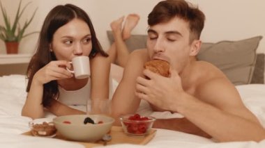 Genç bir çift, sıcak bir kahvaltıyı, kahvesini yudumlayan bir kadınla ve ayçöreğinin tadını çıkaran, aşkının tadını çıkaran bir adamla paylaşır.