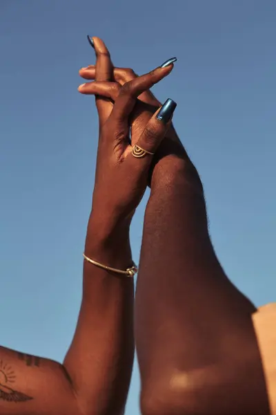 在晴天的统一与爱的概念下 低角度的非洲夫妻手牵着蓝无云的天空 — 图库照片