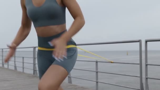 Een Gemotiveerde Jonge Vrouw Grijze Sportkleding Oefeningen Met Een Verzetsband — Stockvideo