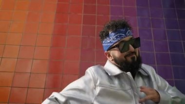 Hip-hop dansçısı, elleri handikaplı eşsiz hareketler sergiliyor renkli bir şehir geçmişine karşı canlı bir performans sergiliyor.