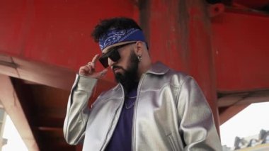 Kendine güvenen genç adam hip hop hareketleriyle sokak stili yeteneğini sergiliyor. Benzersiz tutumunu ve şehir modasını ifade ediyor.