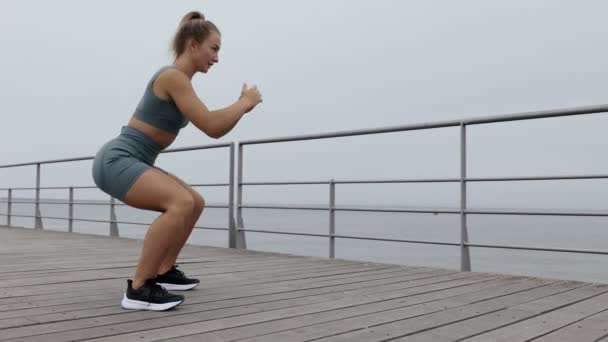 Side View Young Caucasian Woman Activewear Performs Squats Pier Exuding — Stockvideo