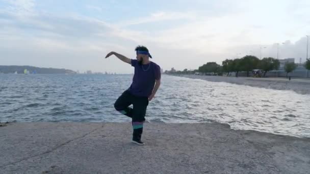 一个都市嘻哈舞蹈家在海边表演他的技巧 街头风格的男舞者 在自然光下欣赏舞蹈 — 图库视频影像