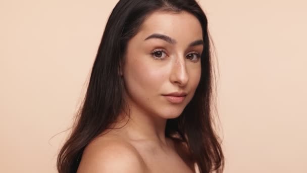 Radiant Young Woman Smiling Bare Shoulders Beige Background Portraying Confidence — Stock Video