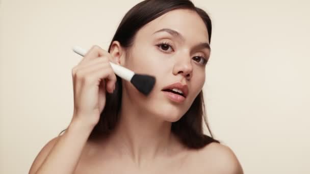 Close Focused Young Woman Applying Blush Foundation Using Makeup Brush — Stock Video