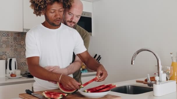 Två Män Delar Ett Ömt Ögonblick Köket Skära Vattenmelon Njuta — Stockvideo