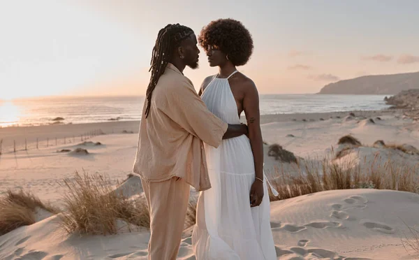 穿着夏装 留着非洲式发型的年轻的非洲裔美国夫妇 站在干燥的草地上 抱着乌云密布的蓝天和海水 面面相觑 — 图库照片